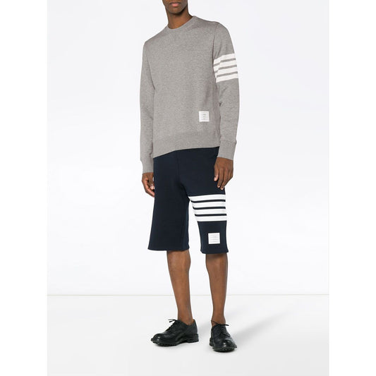 Model wearing Thom Browne Sweaters Light Grey with 4-Bar stripes and name tag appliqué, straight hem, crafted in Japan.