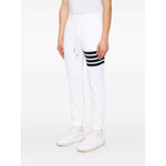 Thom Browne Trousers White with elastic waistband, side pockets, logo patch, and signature 4Bar cotton design.