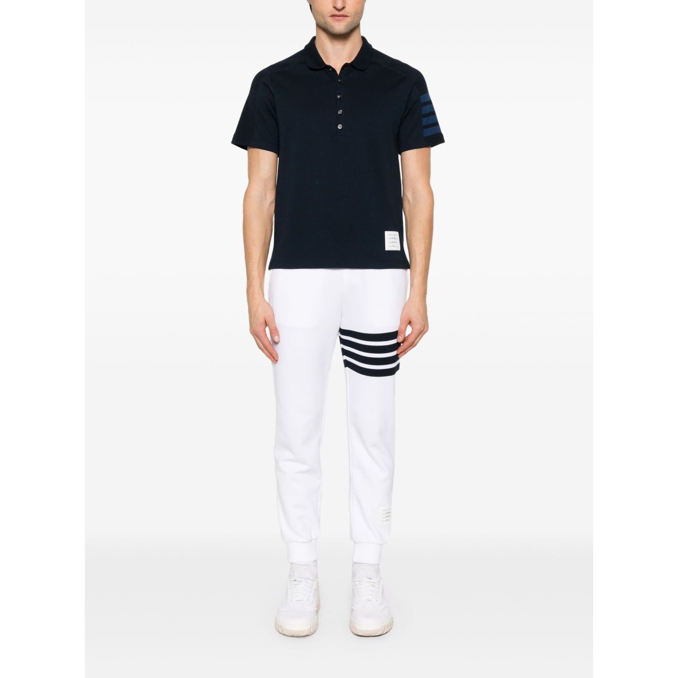 Model wearing Thom Browne Trousers White with elasticated drawstring waistband, side pockets, logo patch, and grosgrain loop tab.