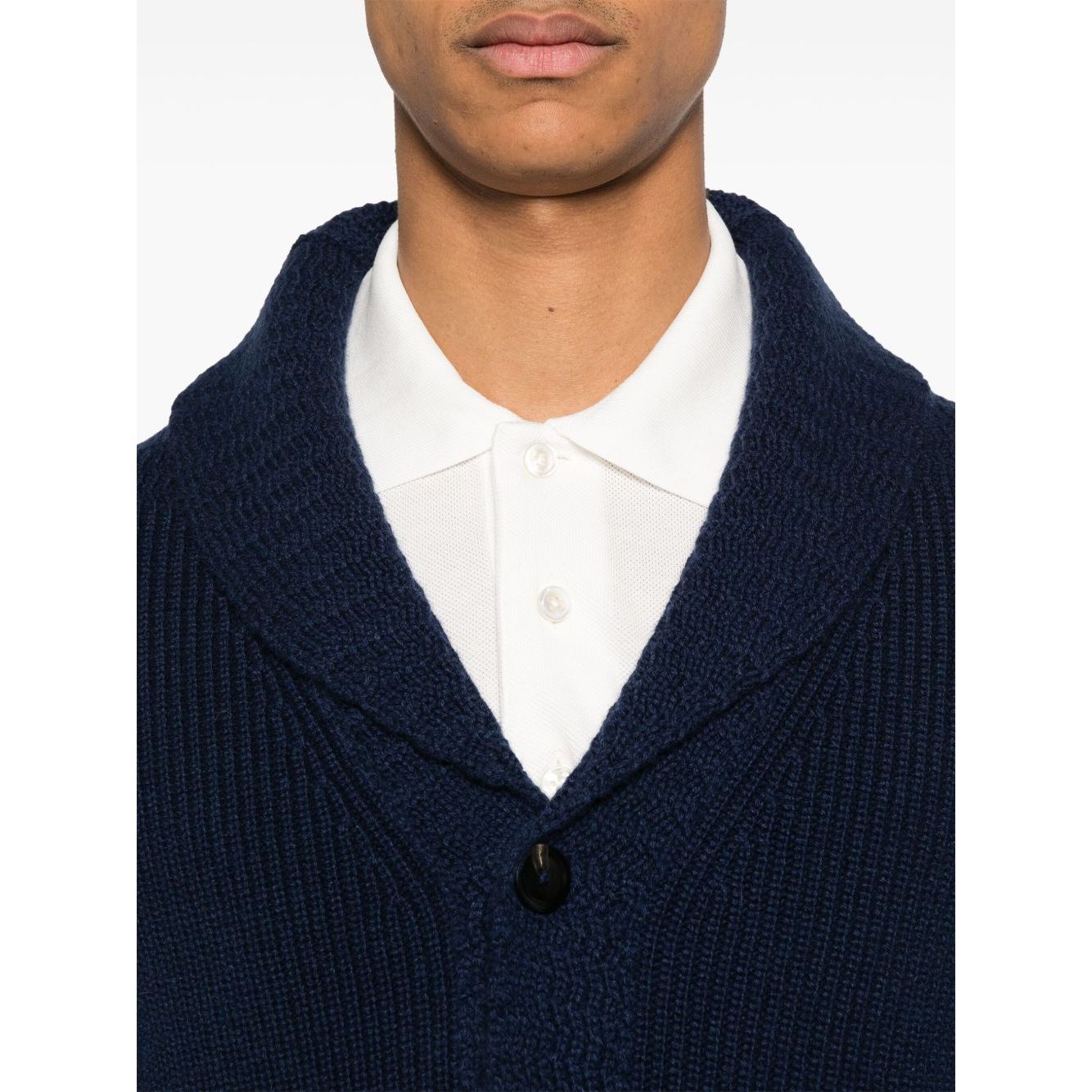 Close-up of a model wearing Tom Ford T-shirts and Polos White, featuring a white polo with button placket and blue knitwear.